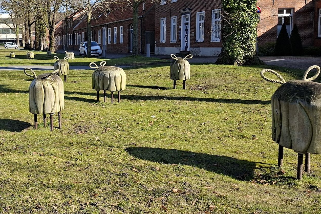 Schaffiguren aus Holz und Metallstreben auf einer Wiese am Georgswall