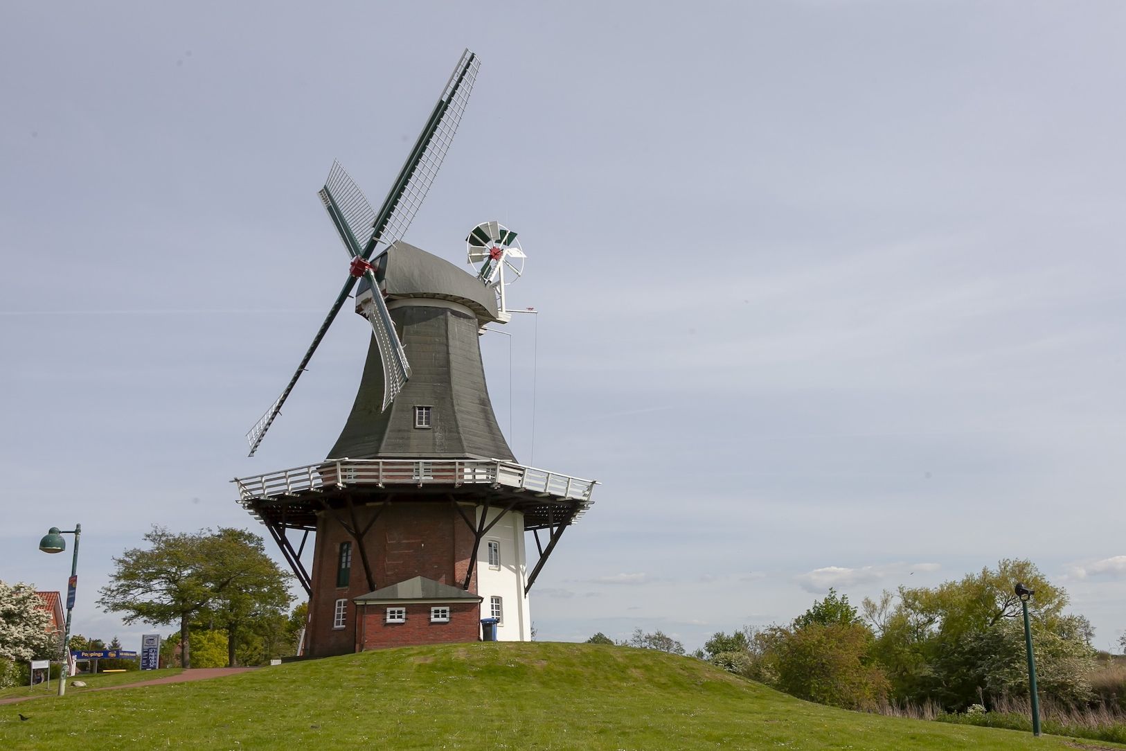 Eine Windmühle auf einer grünen Wiese.